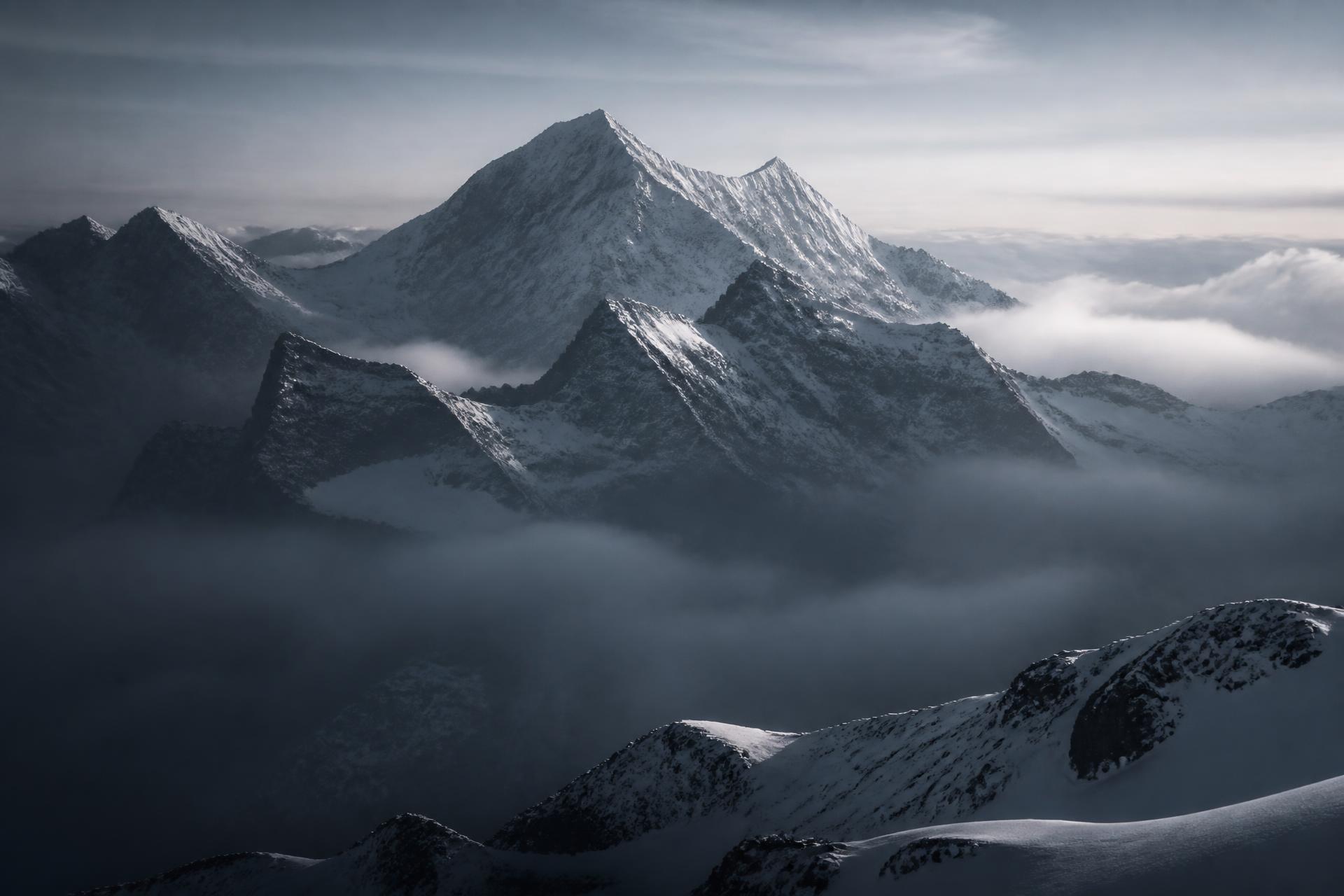 Swiss Alps at dawn, monumental peaks emerging through mist
